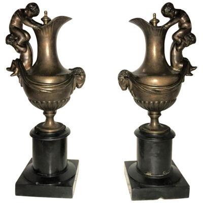 Pair of 19th Century Urns on Marble Stands Bearing Cherubs and Rams Heads