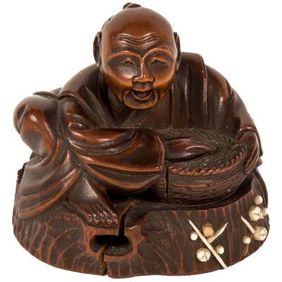 Netsuke of an old man sitting with a basket