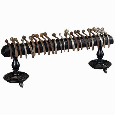 A Collection of 24 Riding Spurs on a Wooden Rack