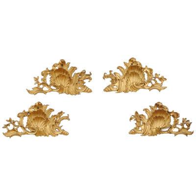 A SET OF FOUR 18TH CENTURY GILT WOOD CARVINGS