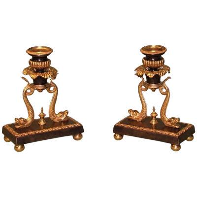 A pair of early 19th Century Regency bronze & ormolu Candlesticks with dolphins