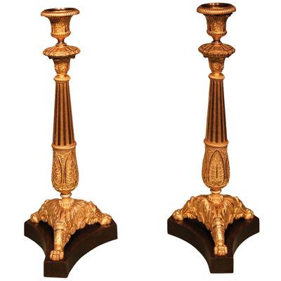 A pair of early 19th century bronze and ormolu candlesticks