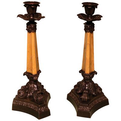 A pair of early 19th century bronze and Sienna marble candlesticks