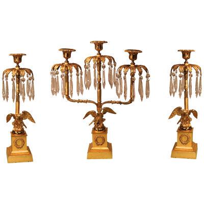 A set of three Regency period bronze and ormolu candlesticks