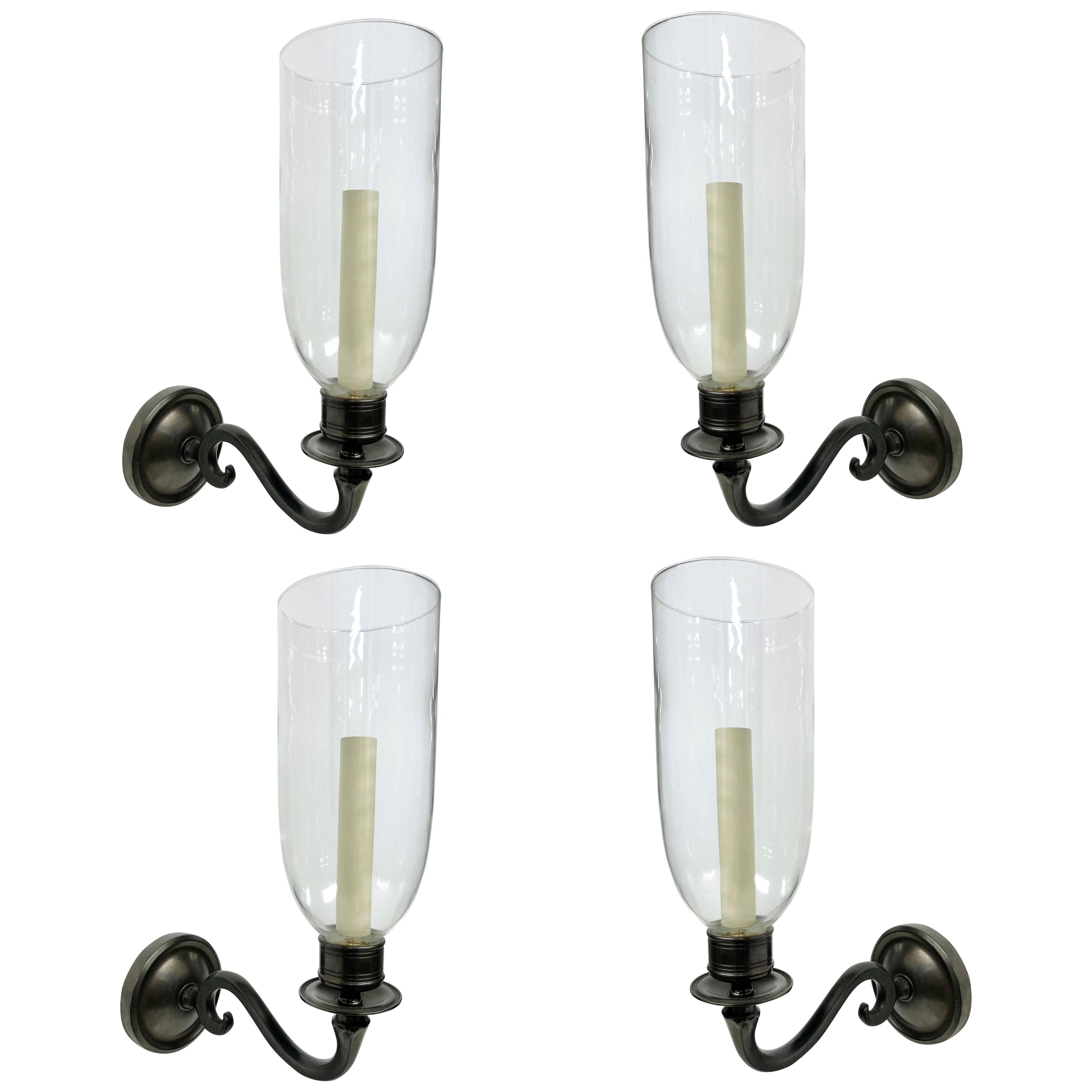 A SET OF FOUR BRONZE SINGLE ARM WALL LIGHTS WITH STORM SHADES