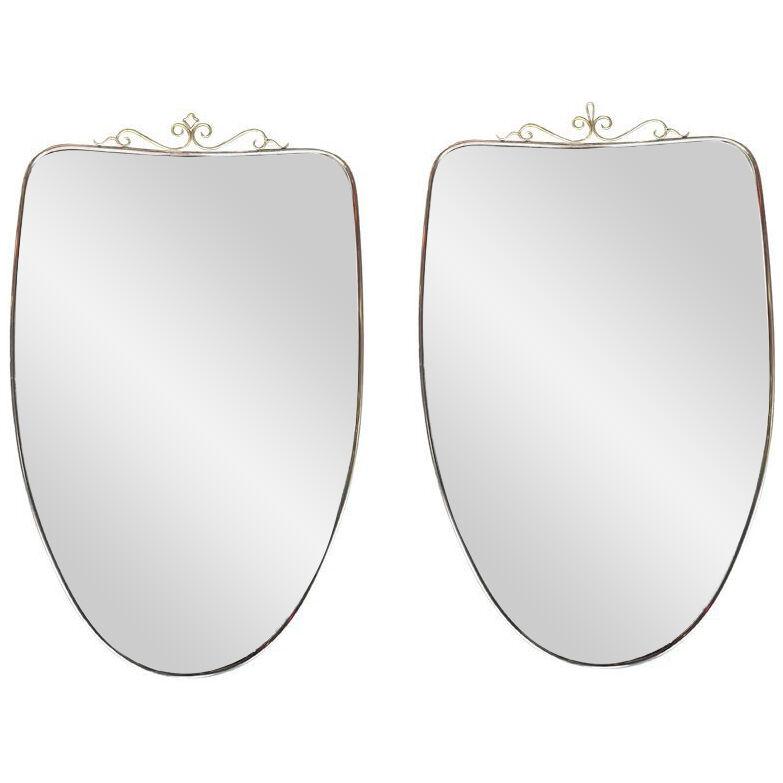 A similar pair of original 1960s Italian shield mirrors with scroll top detail