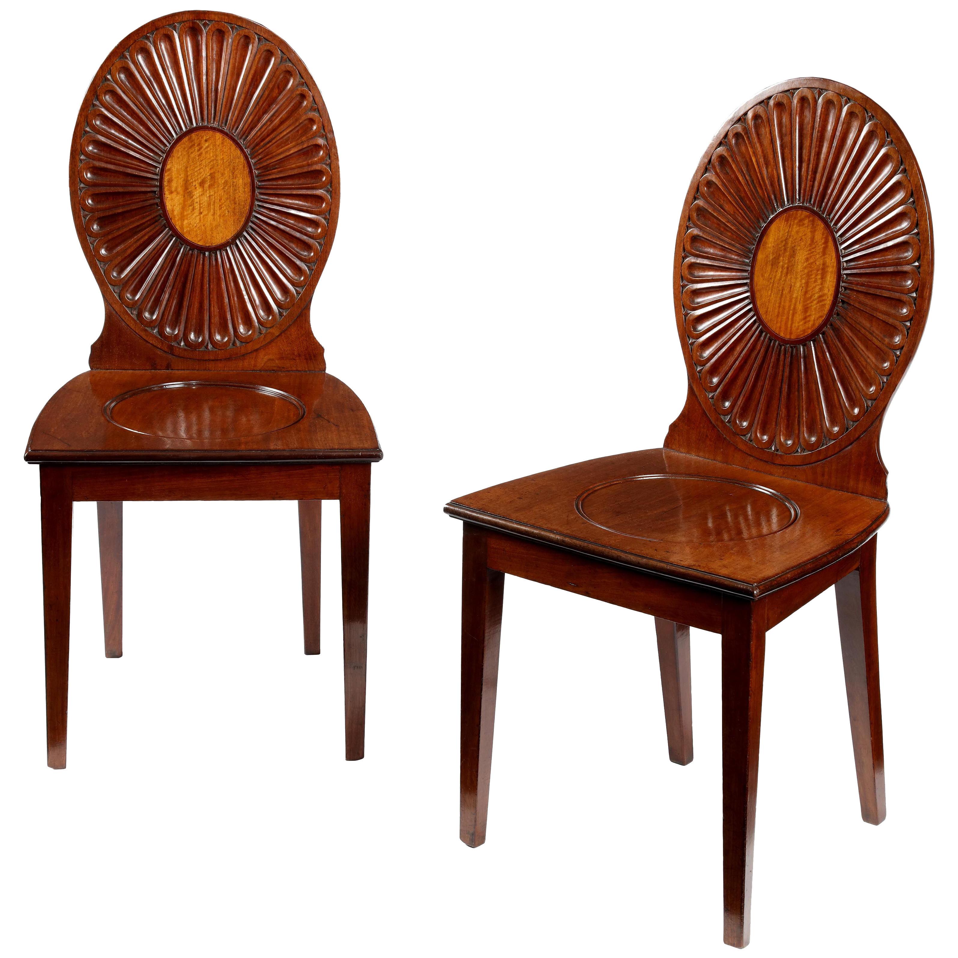 A pair of George III mahogany hall chairs in the manner of Ince & Mayhew