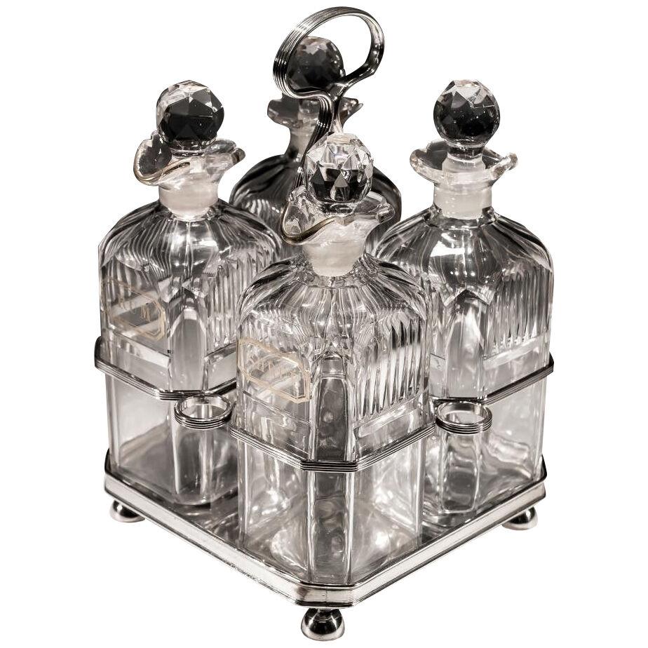 A SET OF FOUR GILT LABELLED GEORGIAN DECANTERS IN SILVER STAND