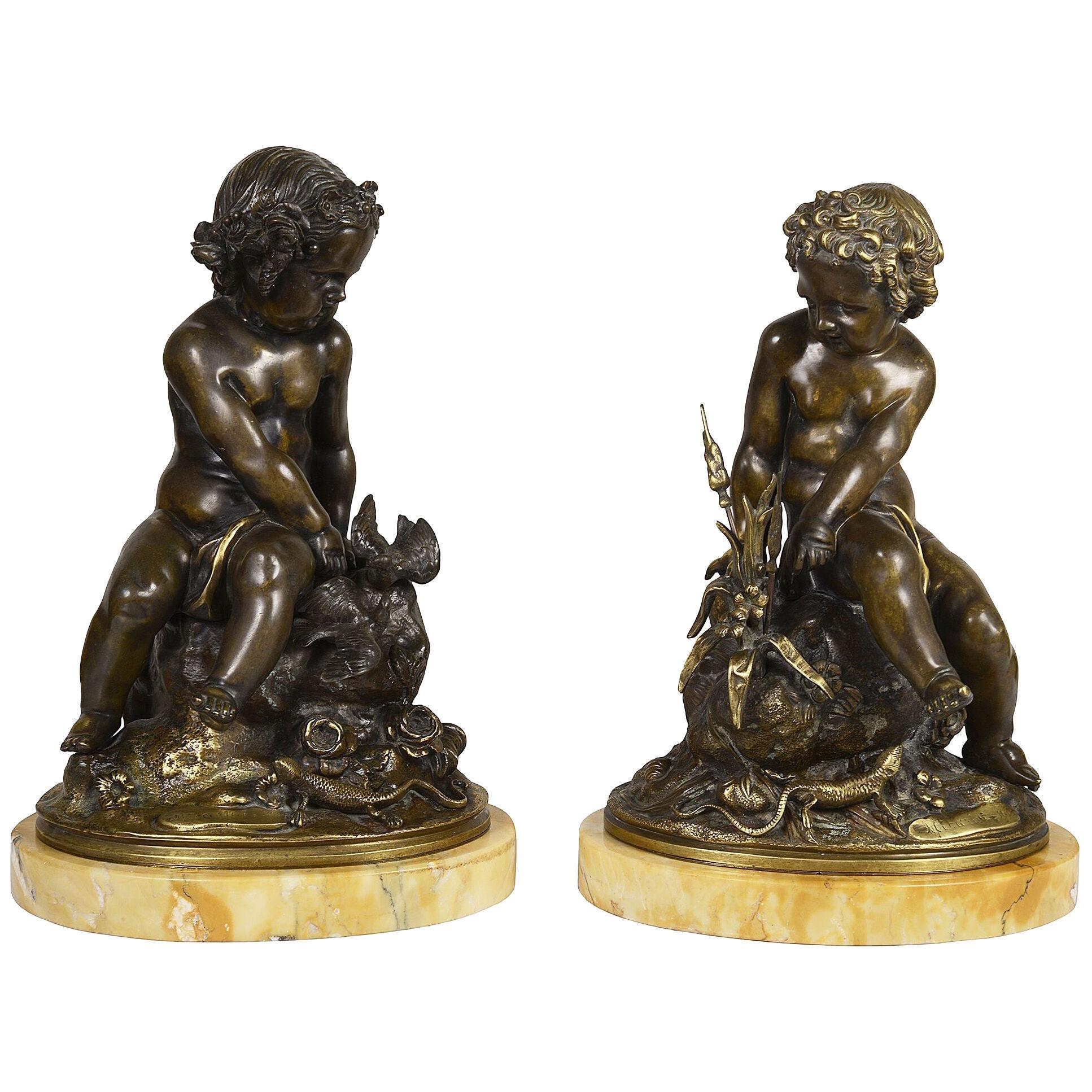 Pair classical 19th Bronze putti seated on a rock