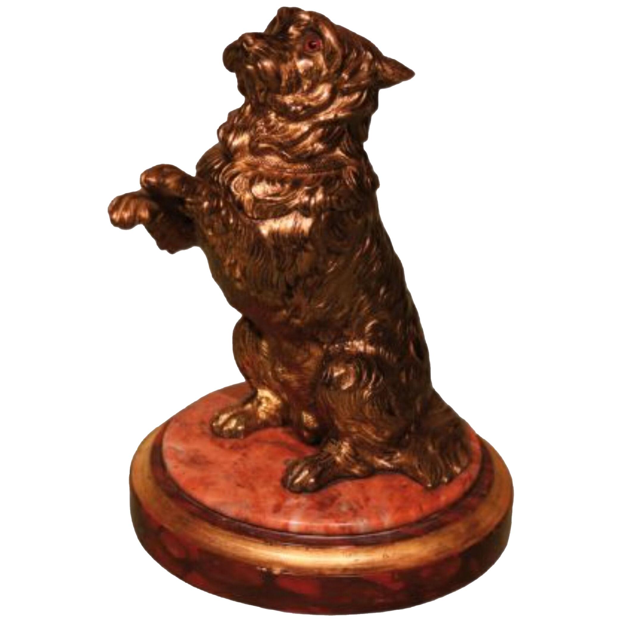 A mid 19th century gilt brass dog on a marble base