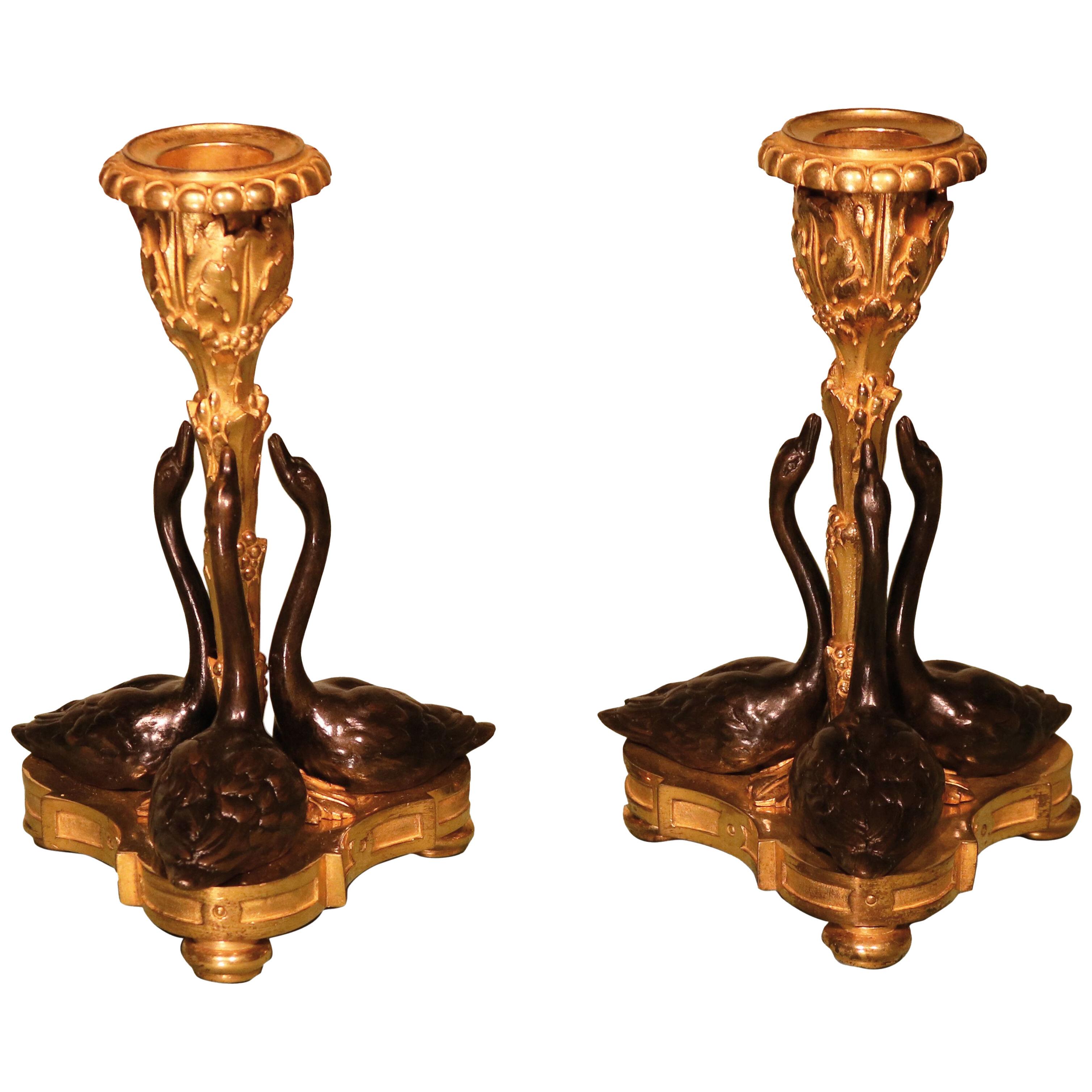 A pair of 19th century bronze and ormolu swan candlesticks