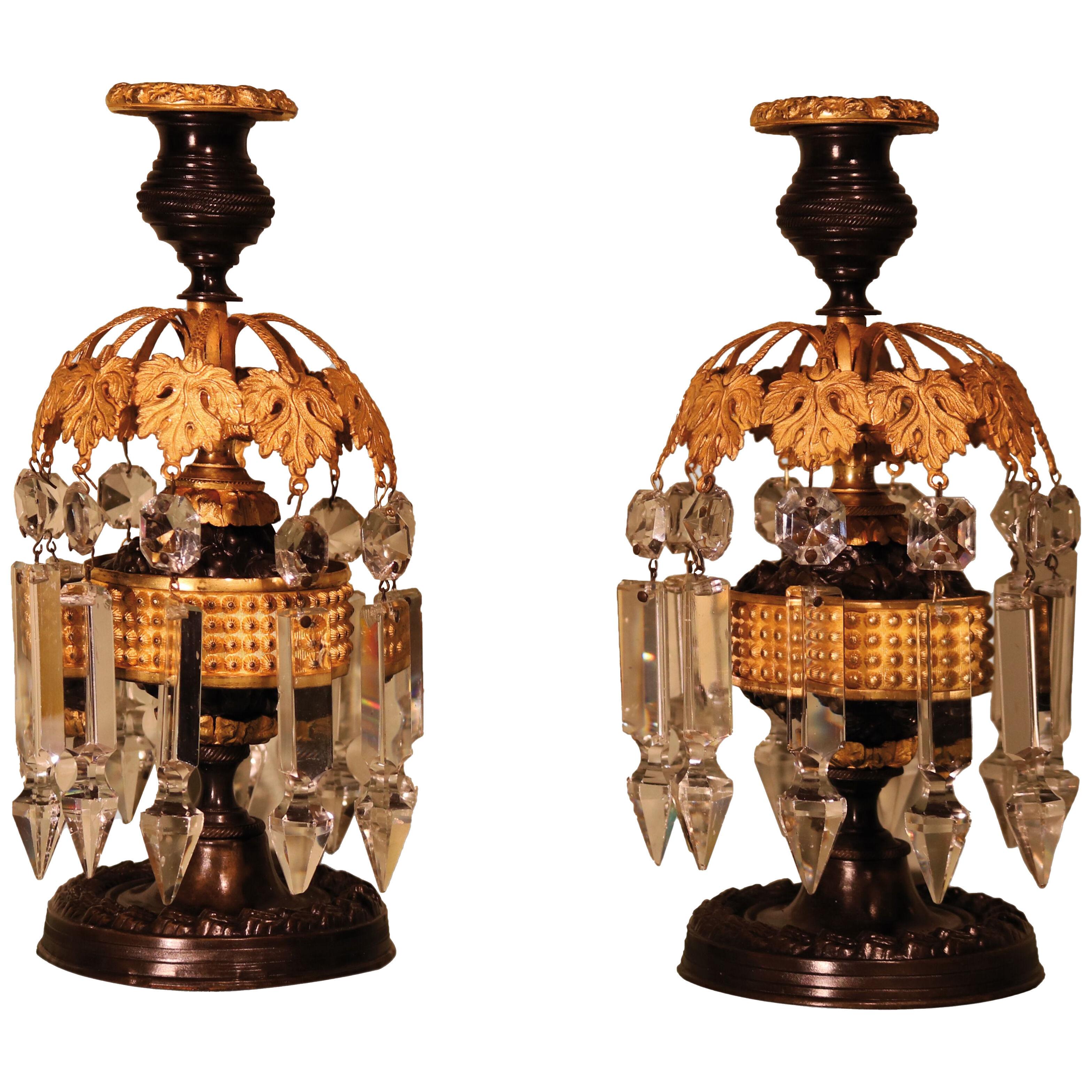 A pair of Regency period bronze and ormolu glass lustre candlesticks