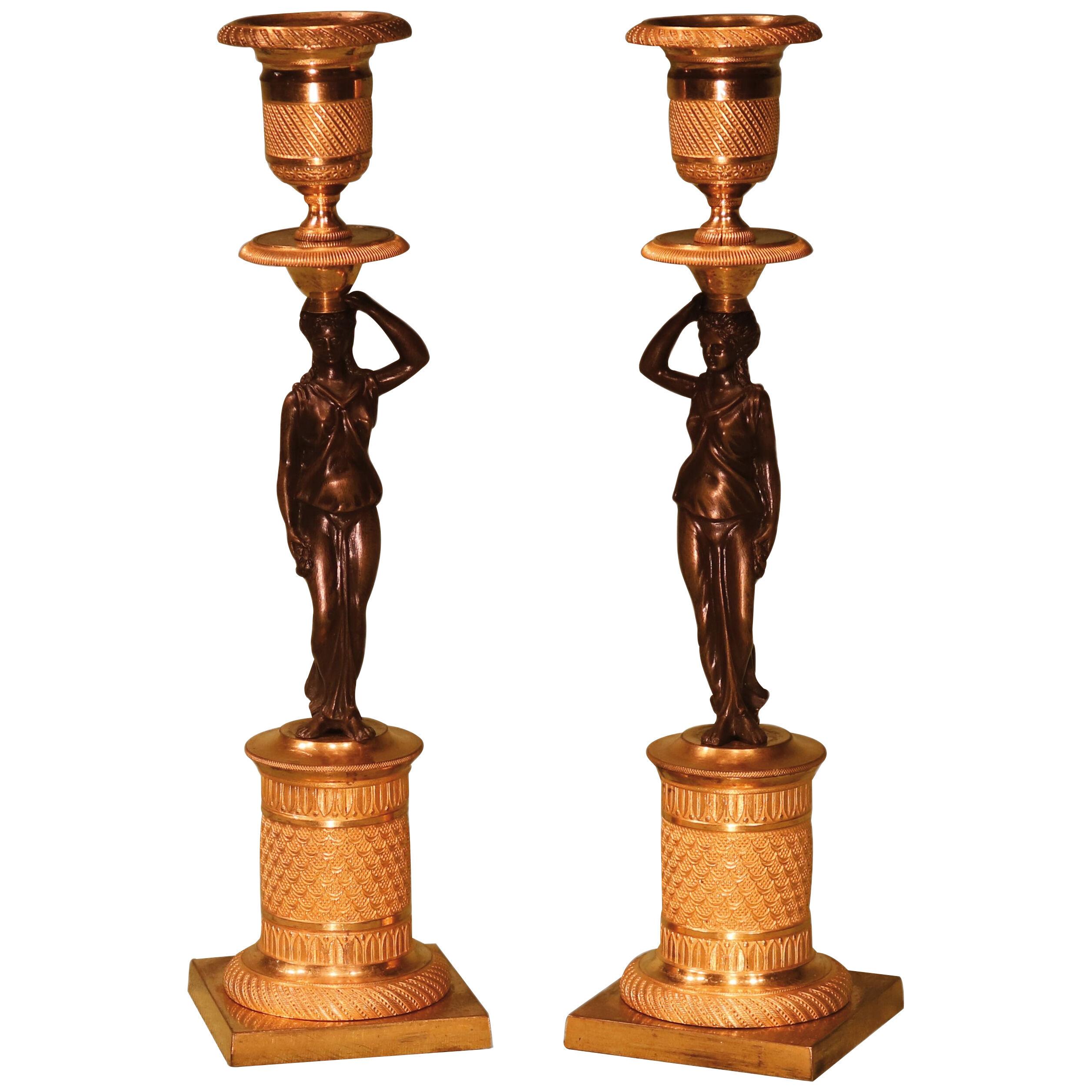 A pair of Regency period bronze and omolu candelsticks
