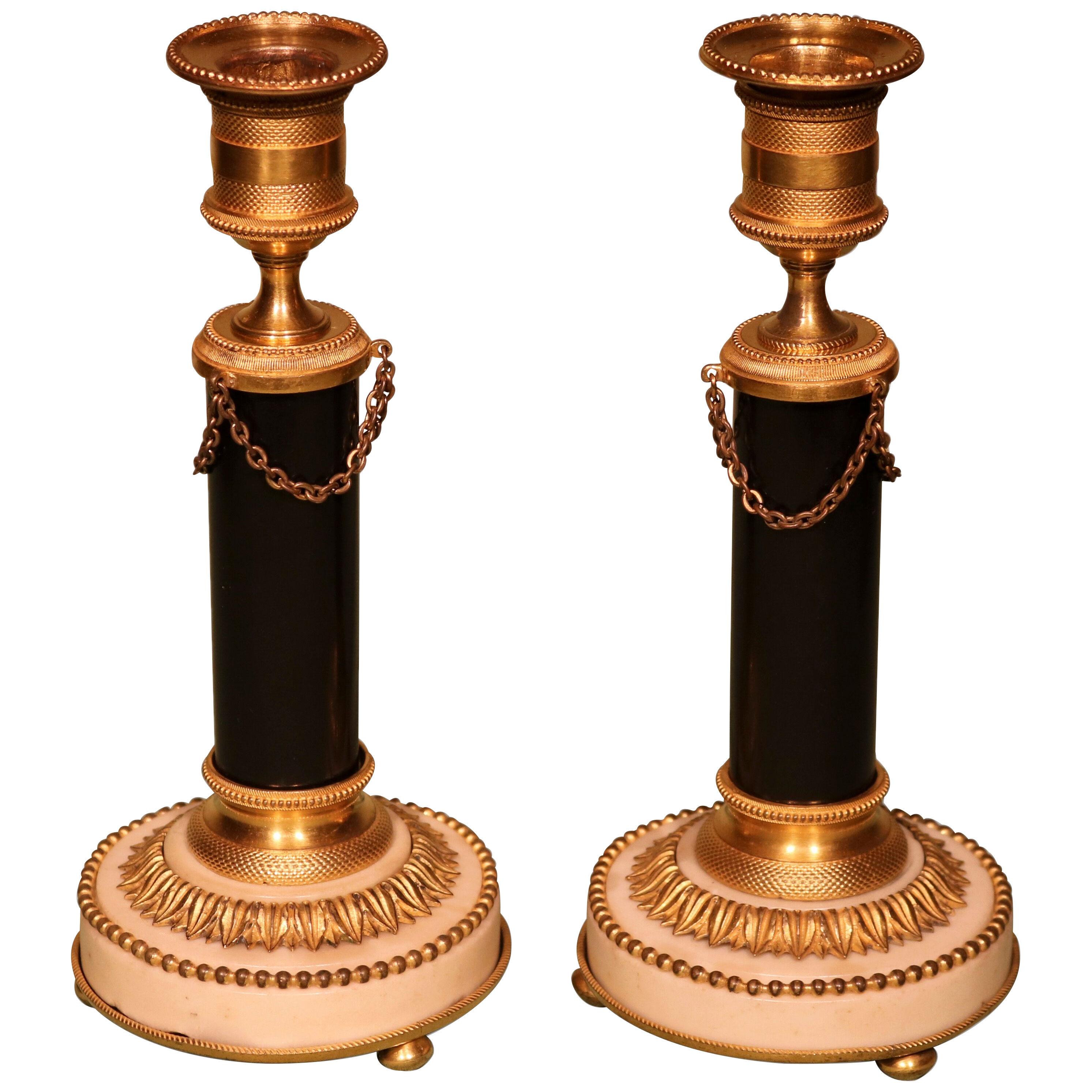A pair of Continental bronze and ormolu and white marble candlesticks