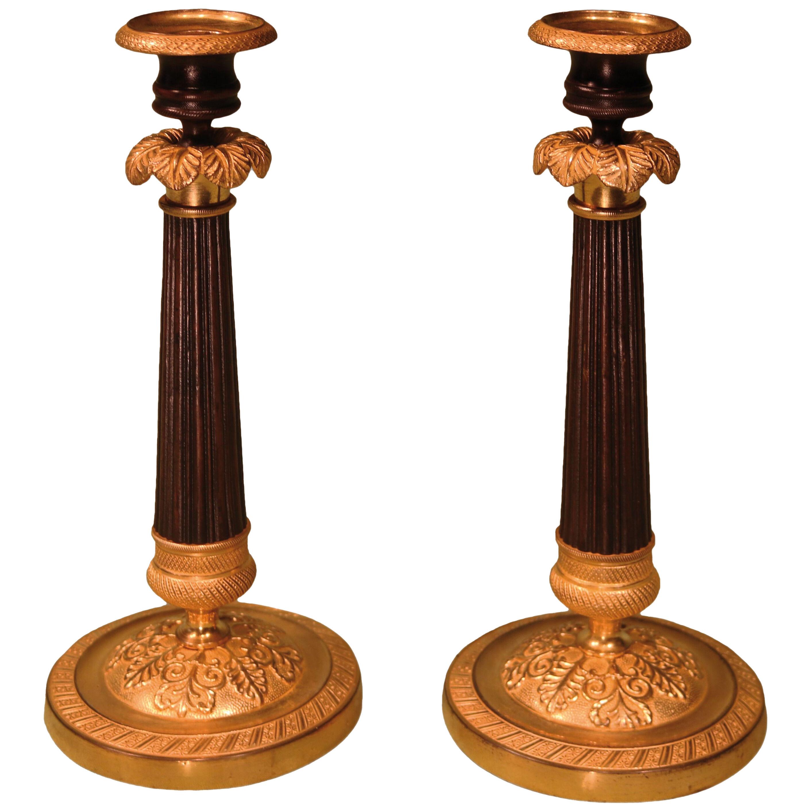 A pair of early 19th century Regency period bronze and ormolu candlesticks