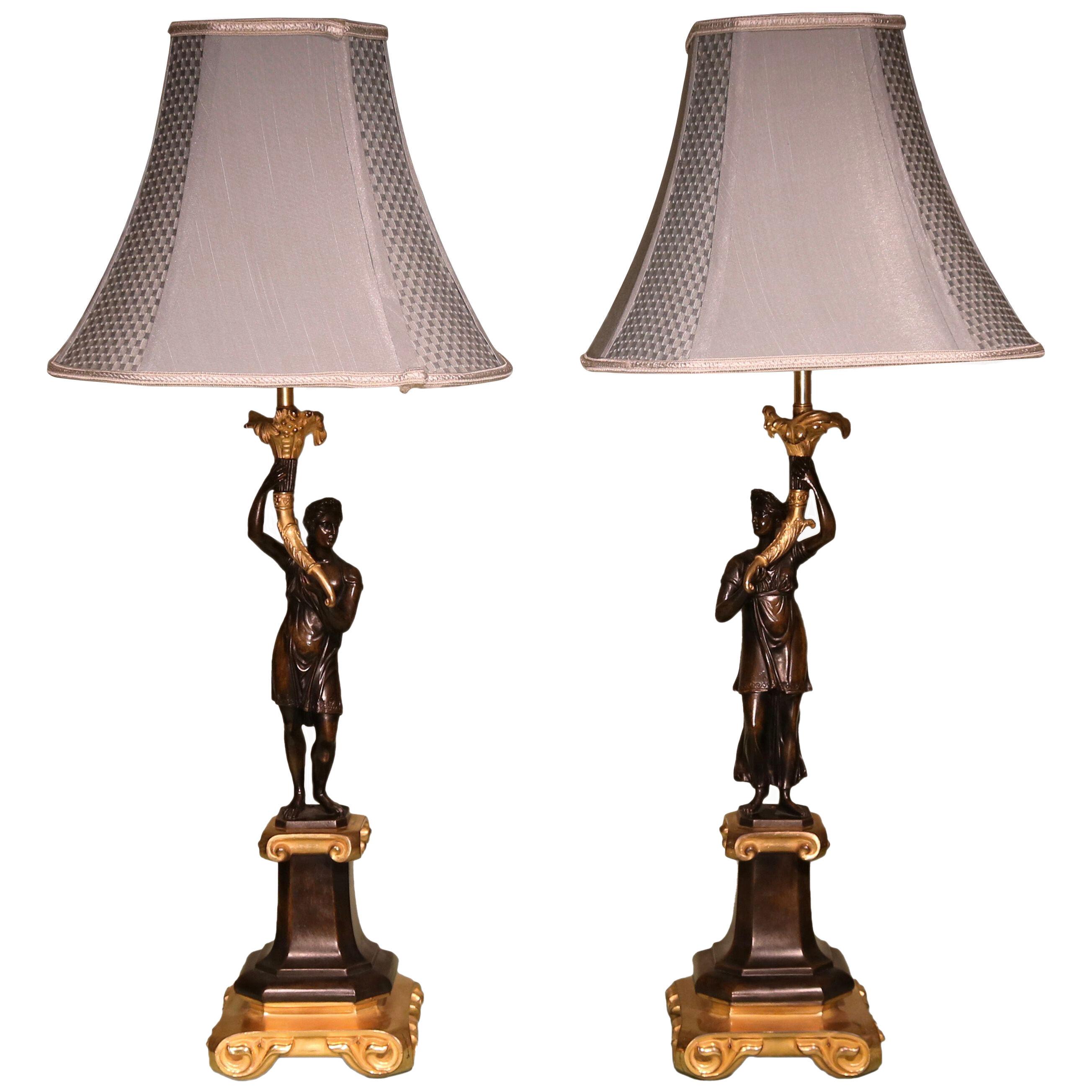 An unusual pair of bronze figure candlestick lamps