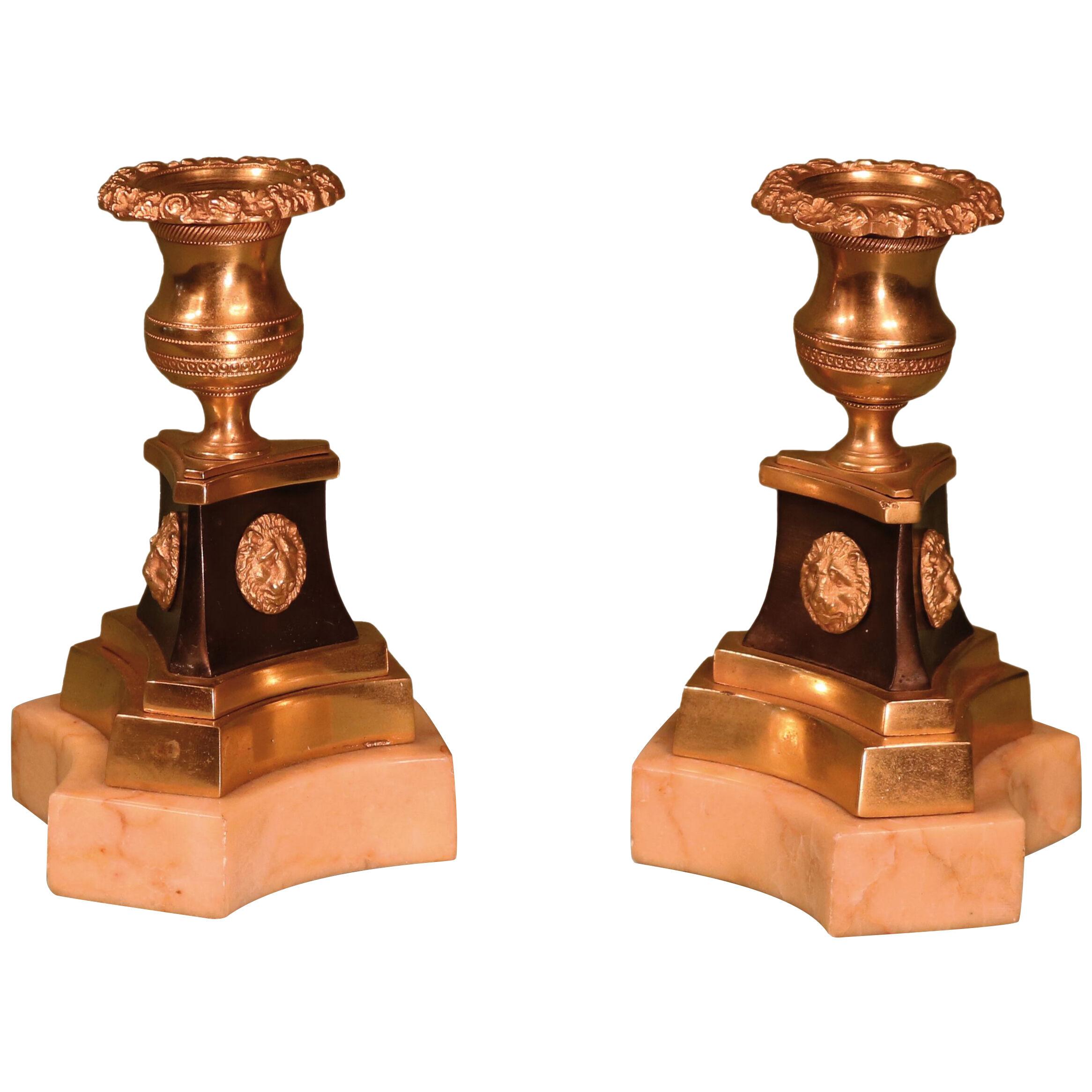 A pair of Regency period bronze and ormolu candlesticks