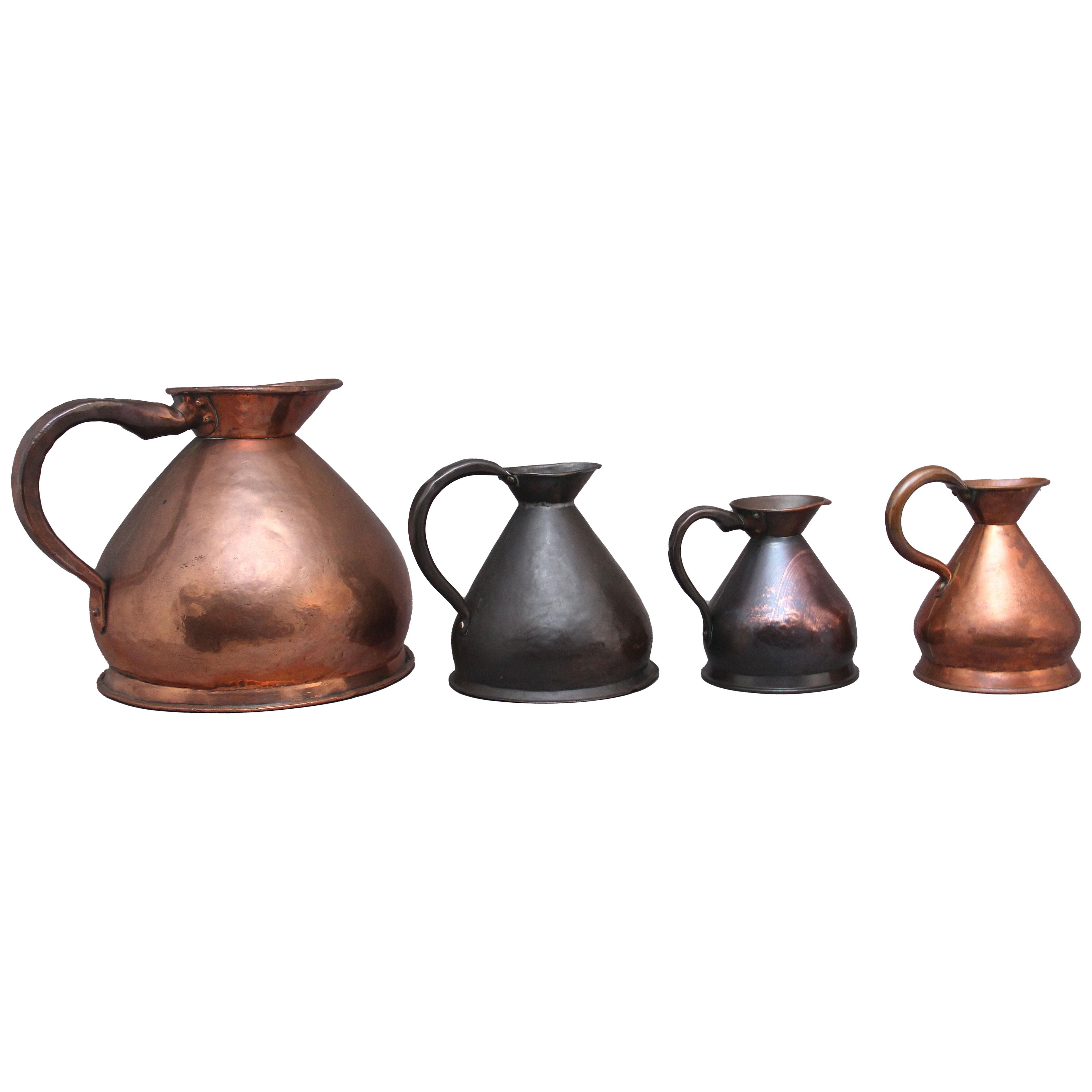 A set of four decorative 19th Century copper measuring jugs